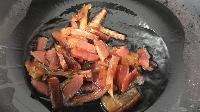 烟熏腊肉炒芹菜,锅里放入少许的油，放入腊肉，小火翻炒至肥肉出油