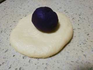 紫薯馅小餐包, 将小面团按扁，放入紫薯馅，收口包紧即可，放入烤盘。