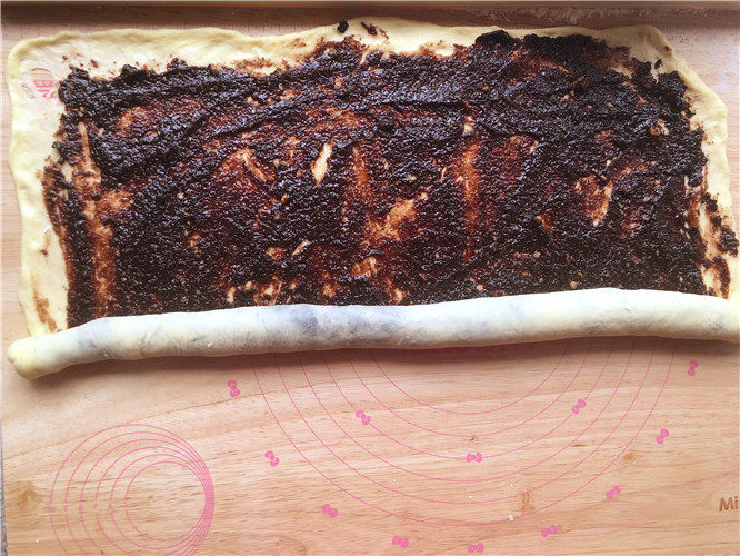 巧克力核桃面包,用刮刀均匀的抹上馅料。从下端向上卷起。
 