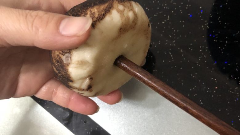 仿真香菇包,拿一个馒头，用筷子在底部戳一个洞。