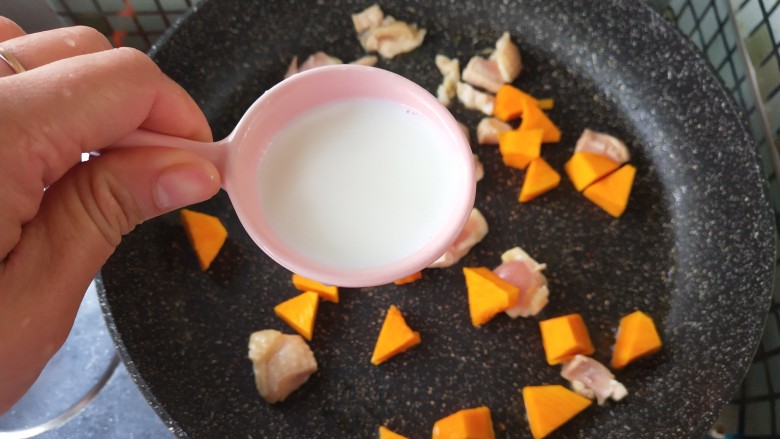 奶香南瓜鸡肉焗饭,放入牛奶，一起炒至牛奶吸变稠。