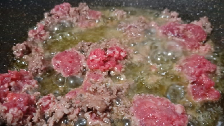 草籽肉末炒年糕,锅肉加适量的菜籽油，下蒜泥炒香再下牛肉翻炒。