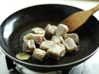 排骨炖豆角,锅内热油，放入姜片爆香后，将焯好的排骨倒入锅中炒匀；