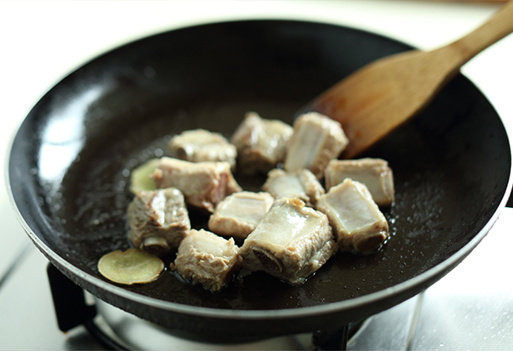 排骨炖豆角,锅内热油，放入姜片爆香后，将焯好的排骨倒入锅中炒匀；