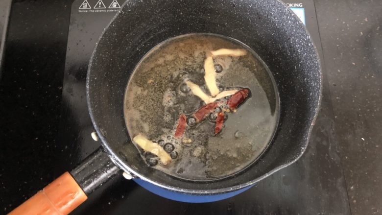 黑木耳香菇烧豆腐,锅内留底油放入姜片、干红辣椒段爆香。