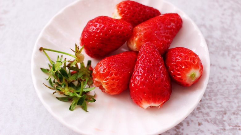 原味草莓苹果奶昔,把冲洗干净的草莓，沥干水分后，去除草莓的蒂。