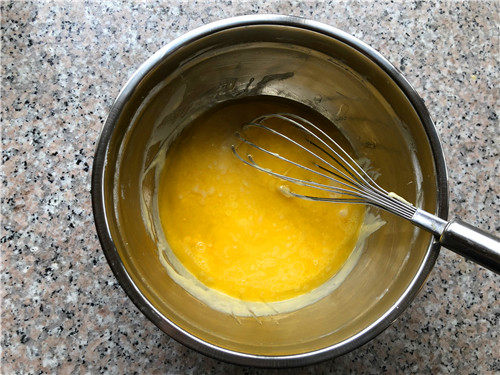 百香果双色玛德琳,倒入混合好的蛋液里，用打蛋器搅拌至黄油和面糊完全融合在一起。
