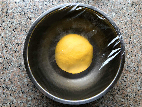南瓜小餐包,继续揉10分钟，取出面团，放到盆里用保鲜膜覆盖，放置温暖的地方发酵。