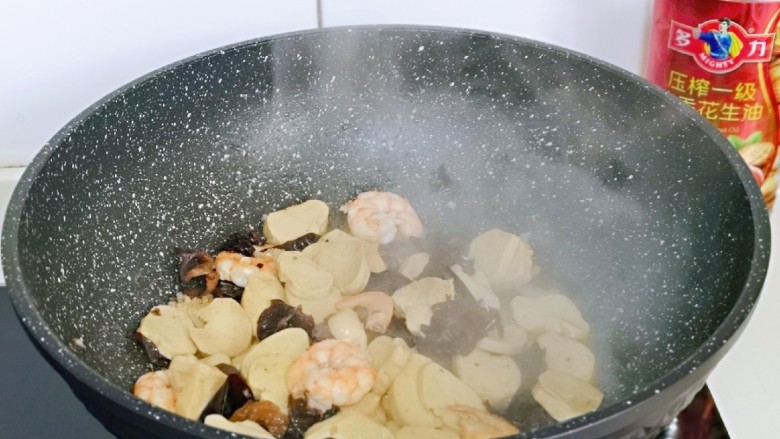素鸡木耳炒虾仁,加入一汤勺纯净水，中小火烧开，翻炒2分钟关火。