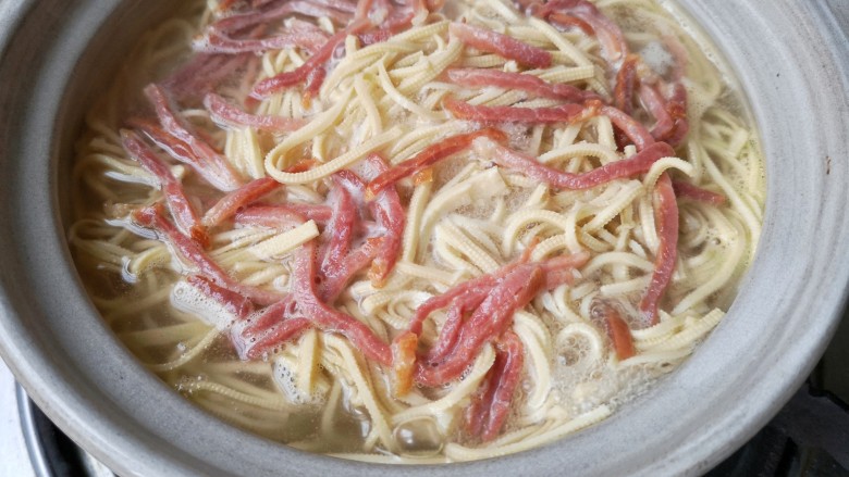 大煮干丝,加入火腿丝，多煮一会，让火腿的咸鲜味充分被千张（豆腐皮）丝吸收。