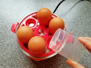 鸡蛋小盏,用量杯下面的钢针将鸡蛋大头一端戳一个小洞(避免煮的过程中鸡蛋破裂)，将鸡蛋放在蛋托盘上面。