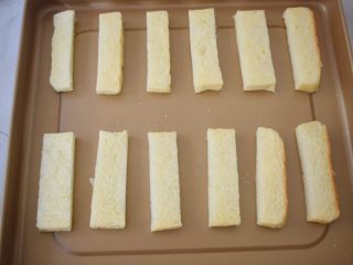 蒜香吐司条,把吐司条摆放在不沾烤盘上，如果不是不沾的，记得要铺上油纸