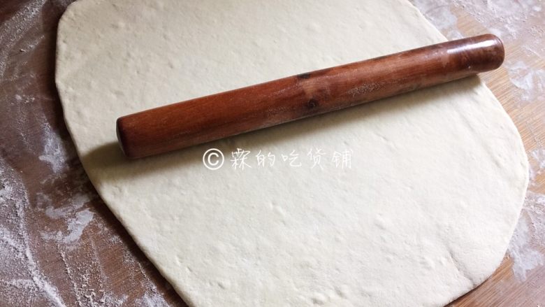 豆沙白玉卷,案板上撒上干粉，发酵好的面团倒上去揉透，然后用擀面杖擀成一张长方形的面片。