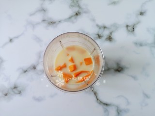 缤纷芒果奶昔,料理机里放入牛奶和芒果打碎成浓稠状。