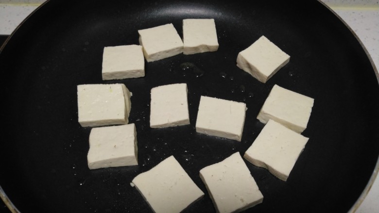 麻辣豆腐炒平菇,锅中放入适量油，放入豆腐。