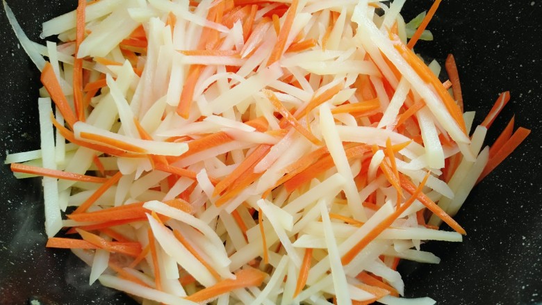 胡萝卜炒土豆丝,放入土豆丝和胡萝卜煸炒