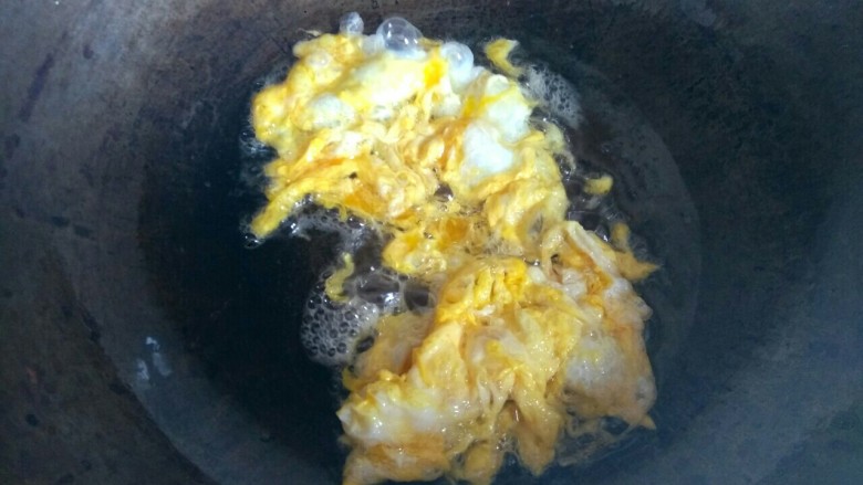 杏鲍菇尖椒炒鸡蛋,锅中放入适量植物油，放入蛋液，煎至成形，铲成小块，盛出待用