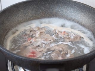 番茄金针菇肥牛卷,肥牛卷焯水， 锅中加入水烧开，下肥牛卷，汆烫变色后立即捞出。
