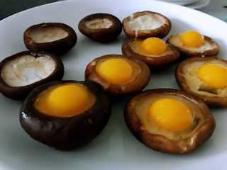 香菇鹌鹑灯盏,拿个稍微深点的盘子，因为蒸的时候要出水，香菇摆好盘，打一个鹌鹑蛋在香菇上，所有的都打完，蛋上面撒点盐。