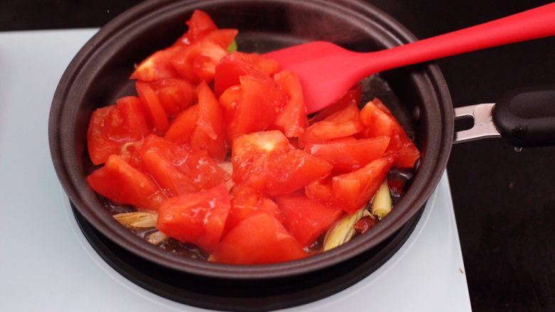 虾滑番茄豆干汤,把切块的番茄放入锅中，大火翻炒均匀。