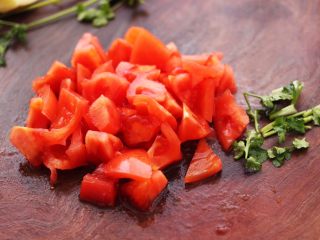 虾滑番茄豆干汤,番茄用刀切块，香菜切段备用。