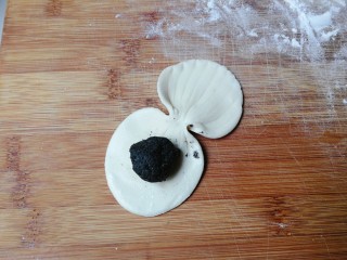 核桃黑芝麻贝壳包,翻面在没有纹路的一边刷手水，放入一个核桃黑芝麻丸