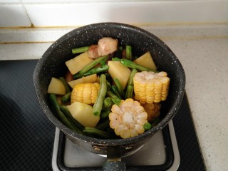 东北乱炖,倒入提前处理好的土豆、豆角、玉米翻炒均匀。