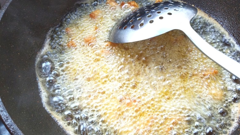 辣子鸡,油烧制7成热，下入切好的翅根块快速的炸至金黄色