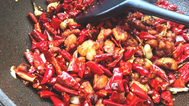 辣子鸡,倒入炸好的鸡块，翻炒出香味，使鸡块和辣椒的味道融合在一起，出锅装盘。