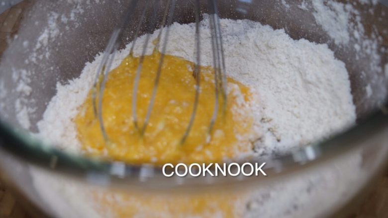 法式玛德琳小蛋糕,倒入面粉的盆中，用打蛋器搅拌均匀。