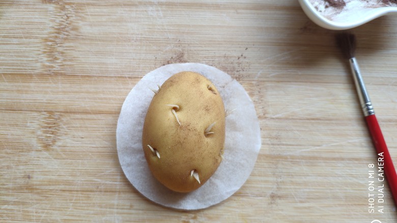 土豆造型豆沙包(馒头),用刷子刷到土豆面团上面。