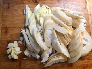 芥菜炒笋,把甜笋根部老的部分削掉，清洗干净切成片，蒜头去皮洗净切蒜片。