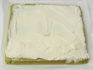 抹茶蛋糕卷,将晾凉尚有余温的蛋糕片放在干净的油纸上，然后抹上打发的淡奶油，头部抹厚一些，尾部薄薄一层就可以了