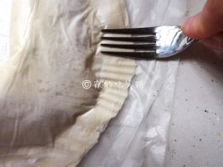 飞饼版  快手香蕉派,用叉子，稍稍用点力，隔着塑料纸刻出花纹（有塑料纸在，面皮就不会粘在叉子上）。