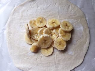 飞饼版  快手香蕉派,撕去一张飞饼上覆盖的塑料纸，另外一张先不要撕，然后把香蕉放到飞饼的中间位置。