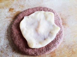 无油无糖紫薯麻薯欧包,面团擀成中间厚边缘薄的圆饼，放抻开的麻薯
