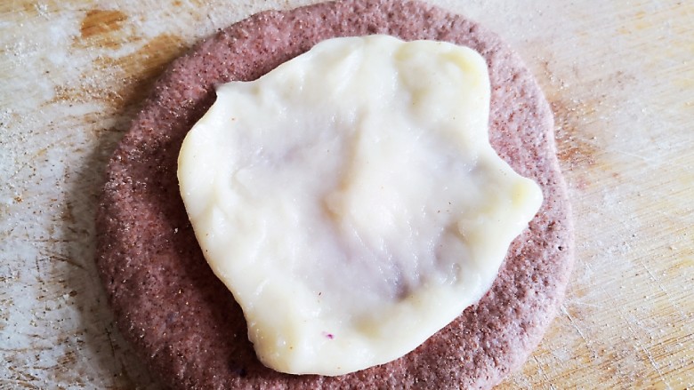 无油无糖紫薯麻薯欧包,面团擀成中间厚边缘薄的圆饼，放抻开的麻薯