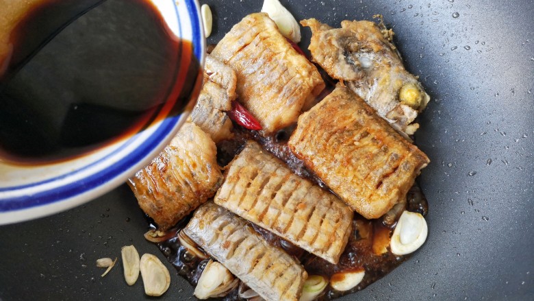 红烧带鱼,将煎好的鱼下锅，倒入调好的料汁，翻炒一下。