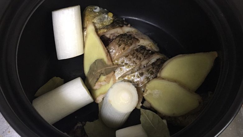 鲫鱼汤,将鱼、葱、姜、香叶加入砂锅