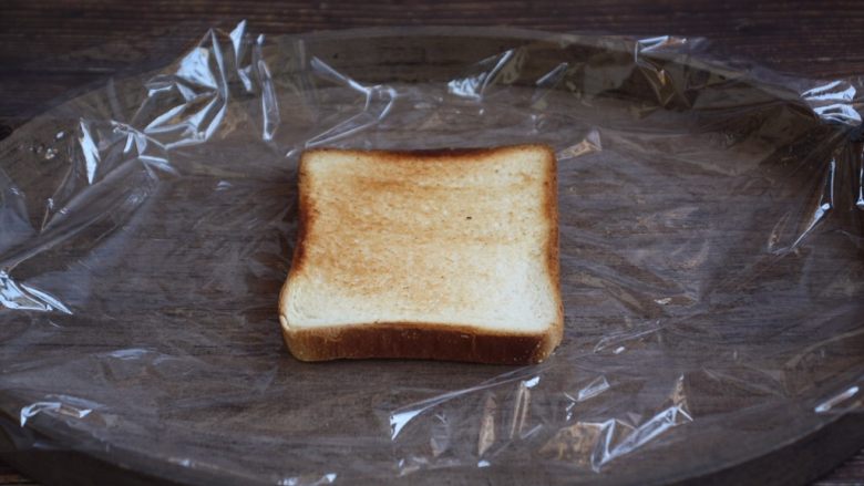 蒸烤鸡胸时蔬三明治（便携美食）,将一片面包切片放在塑料保鲜膜上。
