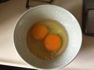 黄金蛋炒饭💛,两个鸡蛋打入碗中。