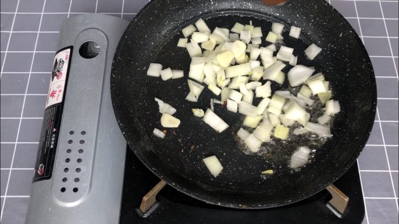 奶油蘑菇培根螺旋意面,盛出培根，留煎培根的油下蒜片和洋葱丁翻炒