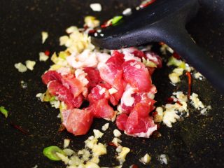 冻豆腐海虾炖番茄,大蒜翻炒出香味后，放入切片的五花肉大火翻炒片刻。