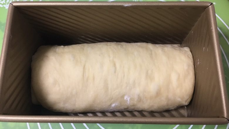 红枣吐司面包,顺势卷起来，放入吐司盒，盖上保鲜膜。