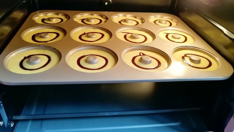 双色甜甜圈,送入预热好的烤箱。