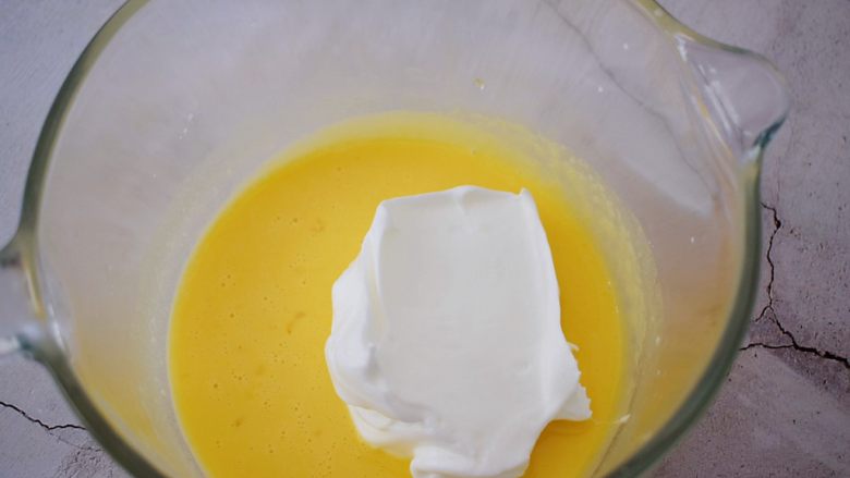 棉花纸杯蛋糕,先取三分之一的蛋白霜加入蛋黄中，翻拌均匀