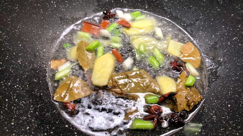 萝卜烧牛腩,锅里放入适量油，先把葱白和姜片放入炒出香味，再把八角、桂皮、香叶放入炒香。