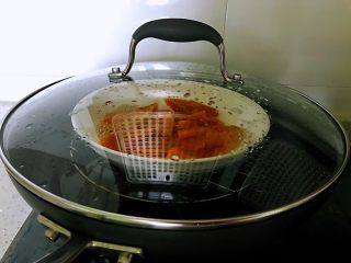 平底锅高钙小馒头,切好的南瓜装入盘中，放在装有水的锅中，盖上盖子，大火烧开转为中火，蒸十分钟。