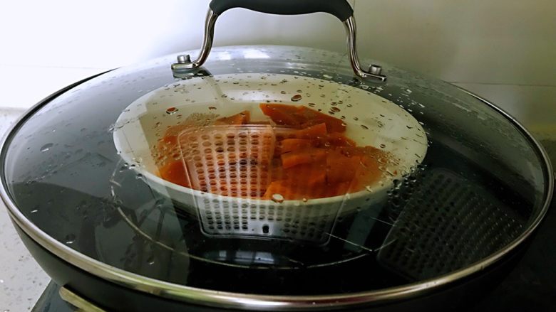 平底锅高钙小馒头,切好的南瓜装入盘中，放在装有水的锅中，盖上盖子，大火烧开转为中火，蒸十分钟。