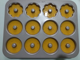 橙香甜甜圈（植物油版）,将面糊挤入到模具内。